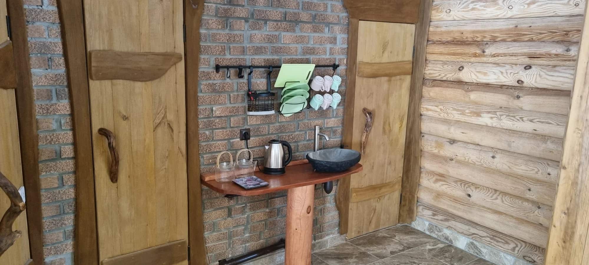 Каменная раковина и деревянные двери в банном комплексе